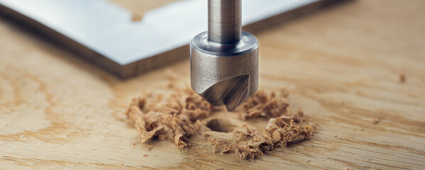 Countersink drill bit with steel triangle ruler make sink in hole for screw in wooden oak plank