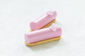 Vegan Pink tea matcha cream dessert bar decorated with a small flower. On cookies. Creamy dessert with the addition of pink pitaya powder. White background