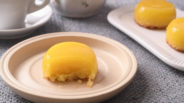 Hand using a fork to take a piece of quindim, traditional egg and coconut brazilian dessert