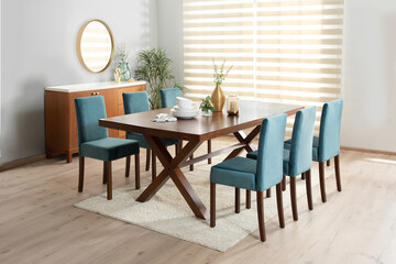 A stylishly arranged dining area with a table and chairs placed against a brightly lit wall