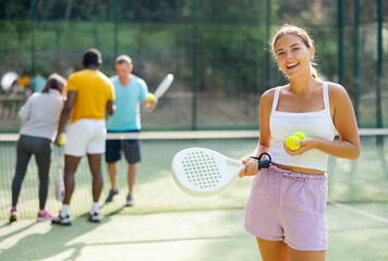 Portrait of a confident European woman tennis player standing with a padel racket and a ball in her...