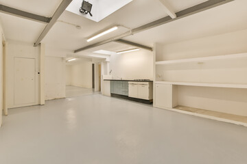 an empty room with white walls and gray flooring, there is no one person in the room to be seen