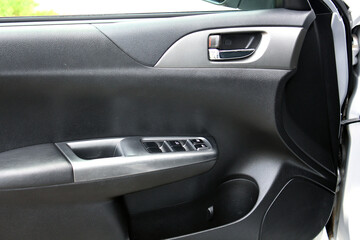 Fototapeta na wymiar Window control buttons in modern car. Car window control panel. Modern car window switch. Door handle with power window control.
