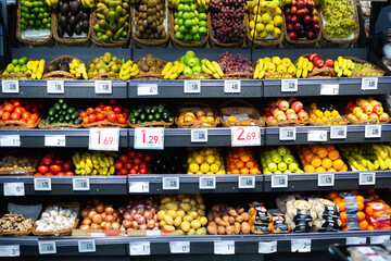Raw fresh vegetables and fruits assortment on counter in supermarket
