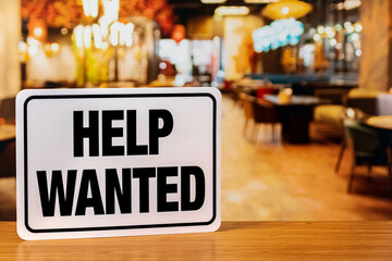 Help wanted sign inside restaurant. Food service industry jobs, labor shortage and unemployment...