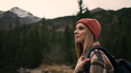Portrait view of blonde woman tourist admiring of the mountain views, enjoying fresh air