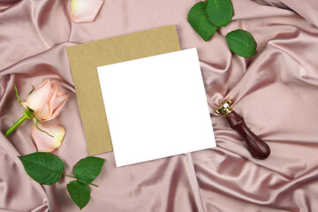 Square invitation wedding program stationery suite mock-up styled with vintage wax seal, and pink rose, on a crushed dusty rose satin background.