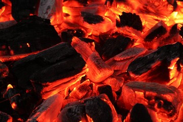 Pieces of hot smoldering coal as background, closeup