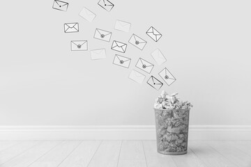 Spam. Drawn envelopes falling into bin with crumpled paper near white wall
