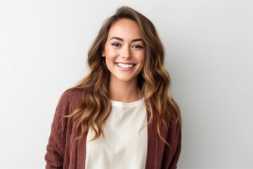 Obraz premium Portrait of a smiling young woman standing against a white background.
