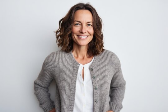 Medium Shot Portrait Photography Of A Pleased Woman In Her 40s That Is Wearing A Chic Cardigan Against A White Background . Generative AI