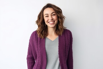 Fototapeta premium Portrait of a smiling young woman in sweater standing against white background