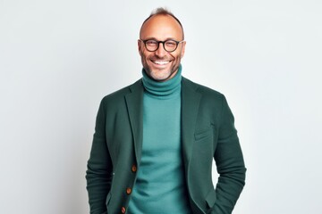 Obraz premium Portrait of a smiling mature man in a green jacket and glasses standing against white background