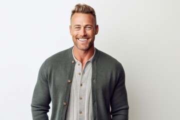 Portrait of a handsome young man smiling at the camera while standing against white background