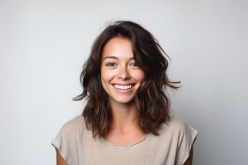 Fototapeta premium Portrait of a happy young woman looking at camera over gray background
