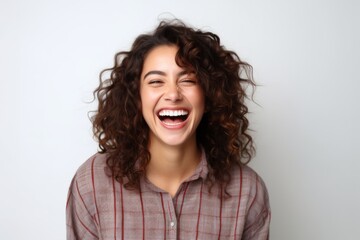 Portrait of a happy young woman laughing on a white background.
