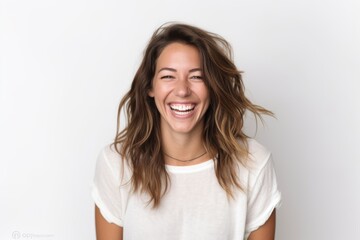 Portrait of beautiful young woman laughing and looking at camera on white background