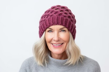 Portrait of a happy mature woman wearing winter hat over white background