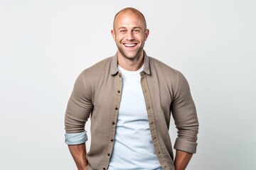 Fototapeta premium Portrait of a happy young man standing with hands in pockets over white background