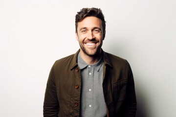 Obraz premium Portrait of a handsome man smiling at the camera while standing against white background