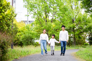 新緑の公園を散歩する日本人の家族