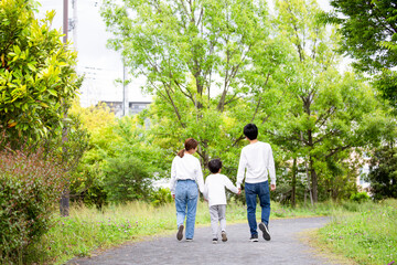 若い日本人ファミリーの後姿　新緑の公園で撮影
