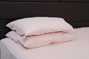 Two pillows stack in an empty bed