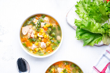 Tasty vegetable soup with chicken fillet, sweet corn and green beans. Comfort food. White table background, top view