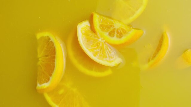 and handfull of orange slices falling into orange juice