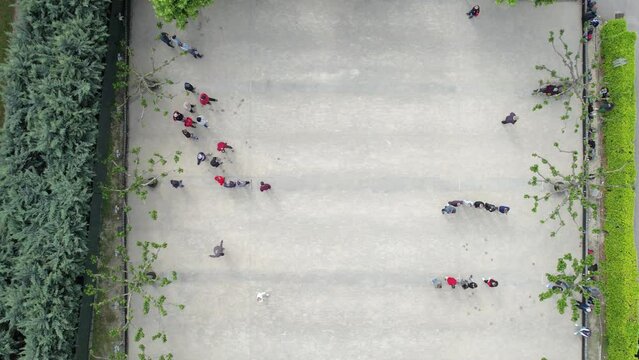 Aerial view of people playing petanque at sandy court playground on sunny day in summertime