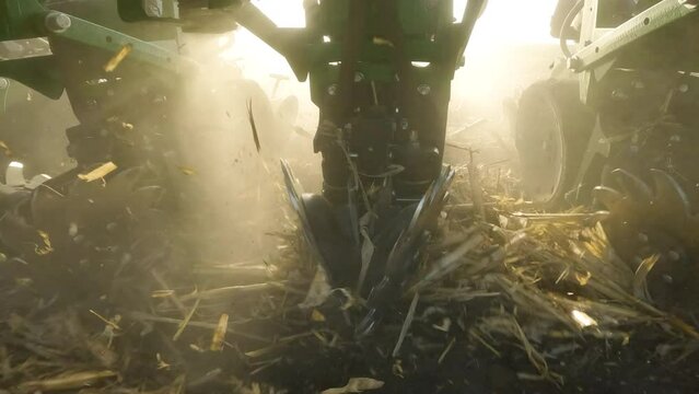 Close up on row cleaner disks of a strip till machine clearing residue while tilling farm land