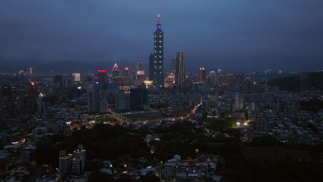 Aerial trucking shot of tower 101 and skyline of Taipei Coty at night