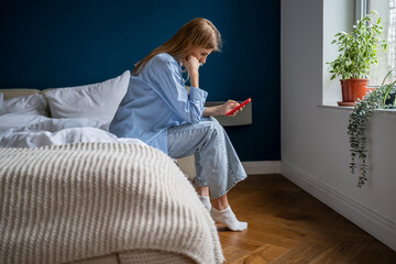 Depressed female holds cellphone pondering bad offer worried think about problem difficult solution...