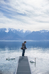 Fototapeta na wymiar Male with Swans at Lake Geneva Vevey, Switzerland.