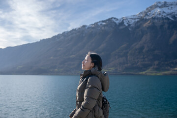 Woman enjoy view the mountain and lake in Iseltwald at Lake Brienz in Switzerland.