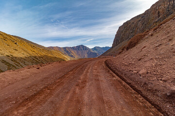 estrada de terra vermelha e montanhas de  Cajón del Maipo e Embalse El Yeso, Chile cordilheira dos...