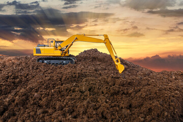 Crawler excavator is digging soil in the construction site  with of sunset  backgrounds.