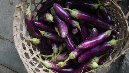 purple eggplant in a bamboo basket. Focus selected