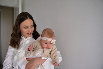 Mother holding her baby girl ready for christening