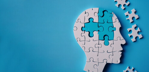 Jigsaw puzzle with human head shape on blue background for Alzheimer day or for brainstorm to drive business ,Generative AI