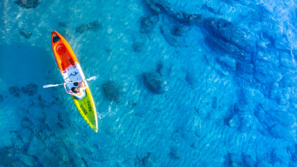Aerial view of a kayak in the blue sea .Woman kayaking She does water sports activities. - obrazy, fototapety, plakaty