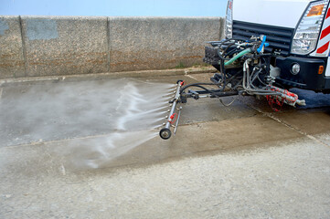 A special machine washes city paths and roads with water