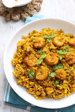 Prawns Biryani or shrimp Pulao. also called jheenga pilaf or jhinga biryani in India. known as Kolambi bhat in Marathi. Garnished with mint leaves, and coriander along with yogurt Raita. Copy space