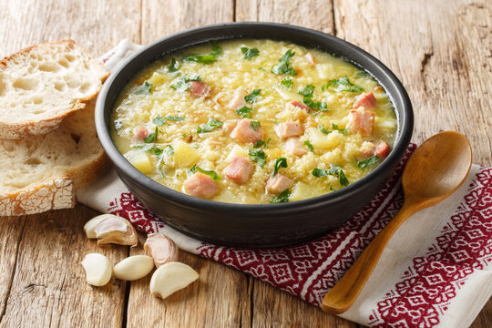 dish of Ukrainian cuisine kulish made of millet, potatoes, onions with bacon close-up in a plate on the table. horizontal