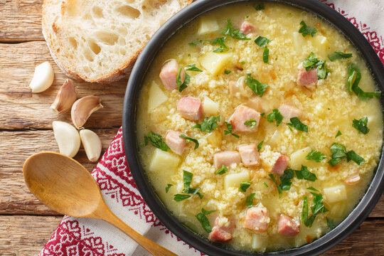 Cossack Ukrainian rich soup kulish made of millet, potatoes, onions with bacon close-up in a plate on the table. horizontal top view from above