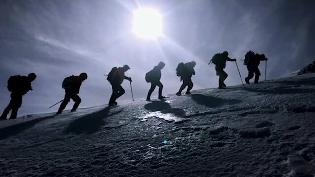 group of mountaineers hiking together in winter