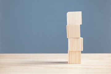 wood empty four blocks stack on table and blue background with copy space for text or symbols,...