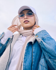 Portrait, fashion or low angle with a muslim woman outdoor in a cap, sunglasses and scarf for...