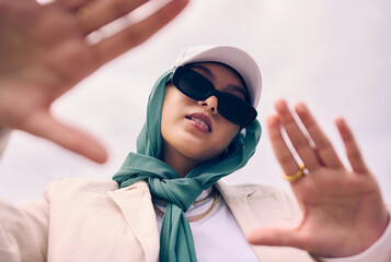 Low angle portrait, woman and city for muslim fashion with gen z aesthetic, streetwear and sky...