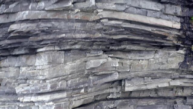 Layers of rock and sediment along exposed eroded hillslope mountain, achill island ireland